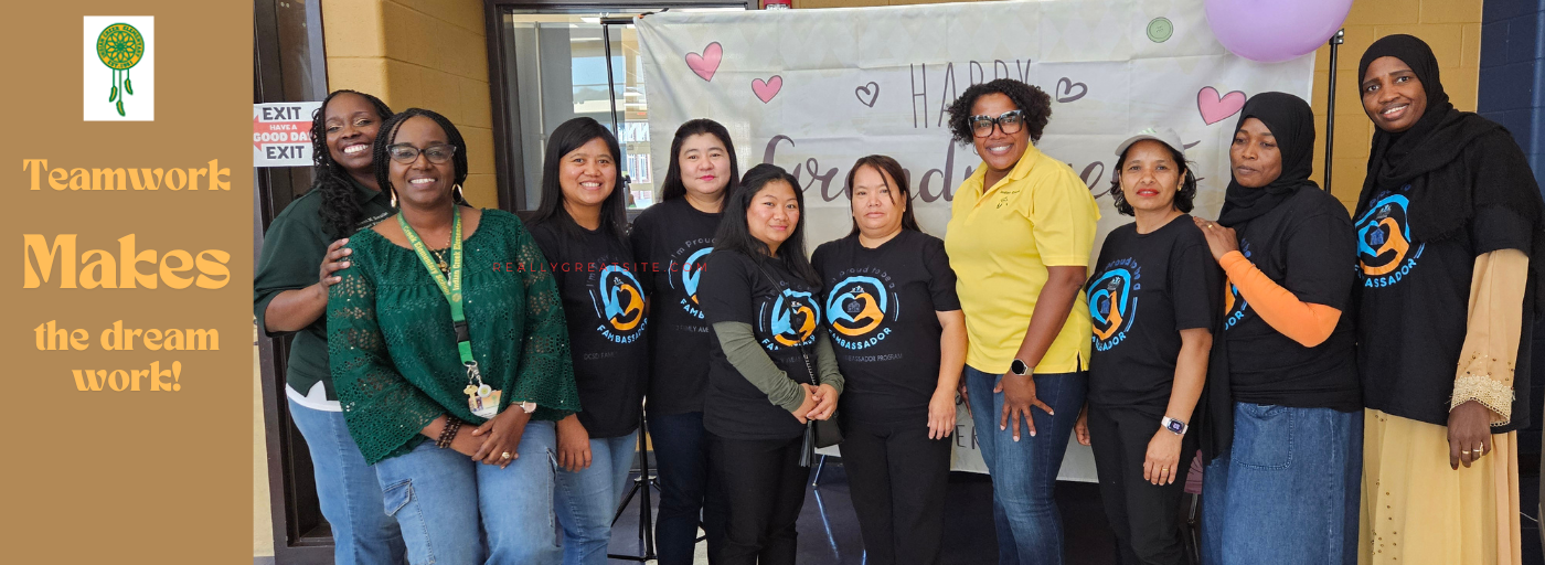 group of women standing in front of a sign smiling; teamwork makes the dream work